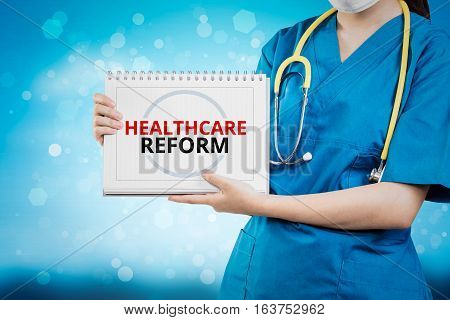 Doctor Shows Healthcare Reform Text On White Line Paper Book.