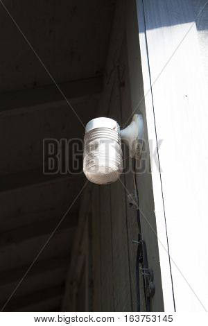 Porch light outside and off during the daytime