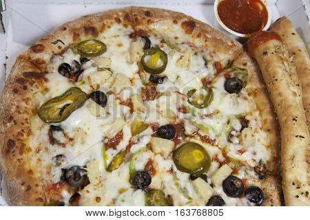 Thick crust olive and jalepeno pizza and two breadsticks with marinara sauce