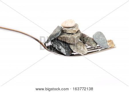 Concept about hard digestion. Fork with stones