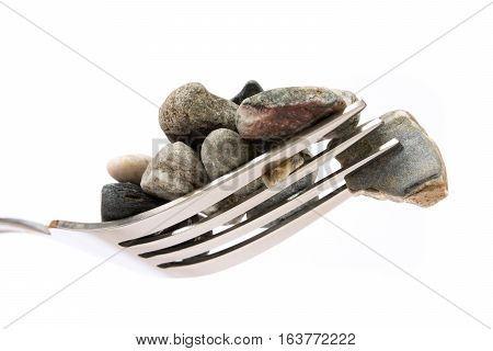 Concept about hard digestion. Fork with stones