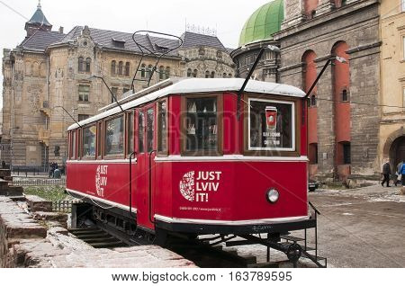 UKRAINE LVIV - DECEMBER 27 2016: red coffee shop on historical buildings background. Lviv red tram which is a touristic shop to buy different souvenirs