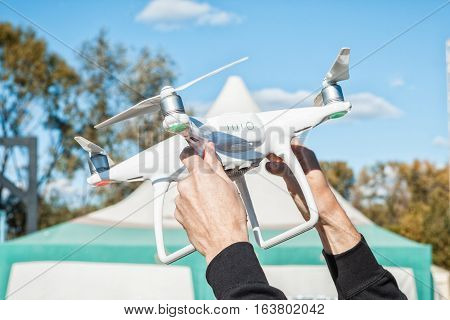 Men's hands hold the white quadrocopter. Preparing the launch of copter