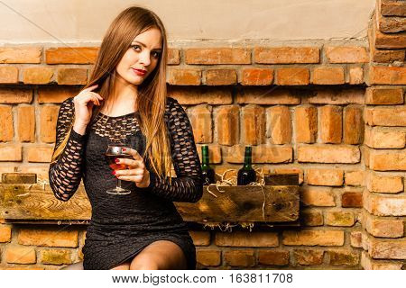 Woman Tasting Wine In Rural Cottage Interior