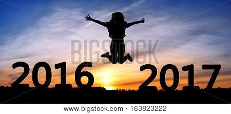Silhouette young woman jumping on the sea and 2017 years while celebrating new EAP, 2017, happy girl. silhouette of girl at sunset, jumping on the background of sunset