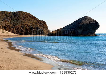 Volcanic rock-formations and crystal clear water at Playa de Monsul. Famous beach in the Cabo de Gata-Nijar Natural Park. Province of Almeria. Spain