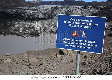 Warning Sign at Solheimajokull Glacier with dark ice. Iceland