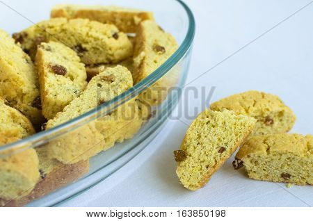 Homemade raisins cookies on white background with place for text. Glass dish with freshly baked raisin cookie. Healthy breakfast. Tasty cookies for an afternoon snack. Selective Focus. Copy space.