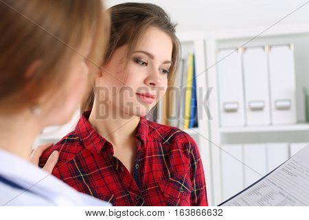 Friendly female doctor touching patient shoulder for encouragement empathy cheering and support after medical examination. Trust and ethics concept. Good news healthcare and medical service concept