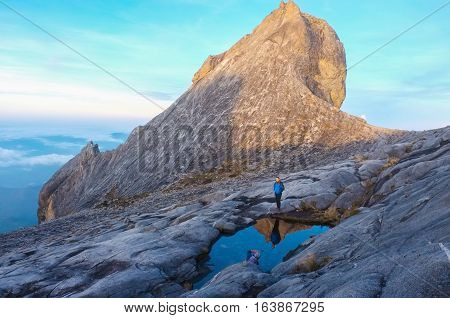 Ranau,Sabah-April 30,2014:Climber stand on the lake with background of StJohn Peak on the top of Mount Kinabalu,Sabah.Mount Kinabalu is the tallest mountain in Malaysia & the 20th tallest in the World