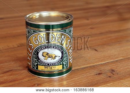 Camberley England - December 11 2016: Tin of Lyle's Golden Syrup - once called Tate and Lyle Golden syrup is s a thick amber-coloured form of inverted sugar syrup made in the process of refining sugar