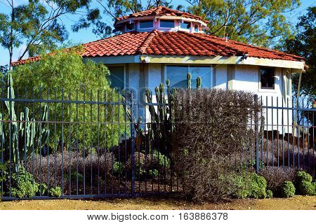 Drought tolerant yard with cactus and chaparral plants beside a Spanish style hacienda villa