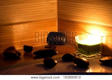 black lava stones massage and a green candle