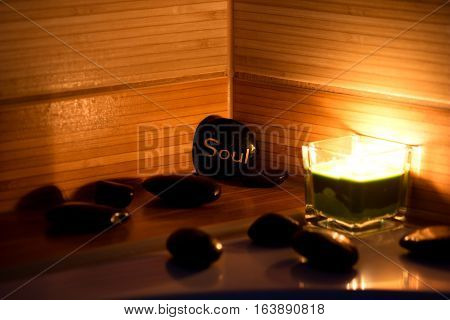 black lava stones massage and a green candle
