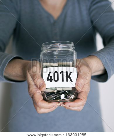 401k plan concept with senior holding money jar