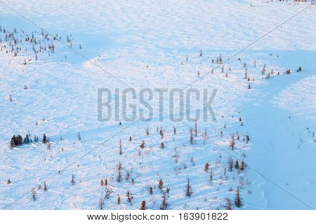 Aerial view above the snow covered tundra in time of short winter day.