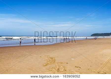 People On Early Morning Beach Against Ocean Skyline