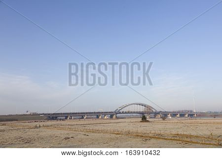 bridge over motorway A2 and wintry meadows in floodplains of river Lek near Vianen in the netherlands