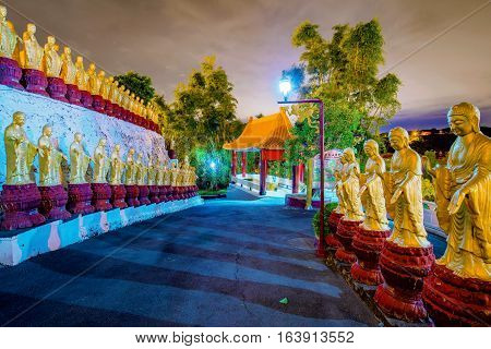 View of gold Buddha statues and temple at night