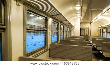 The interior of a passenger train with empty seats