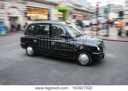 London, UK - 19 December 2016: Black cab taxi in motion on the London's street