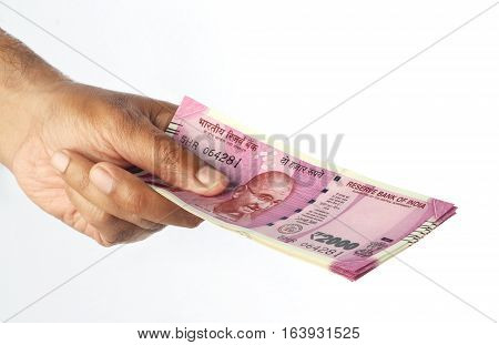 New Indian Rupee 2000 Currency Note in a Hand isolated on White