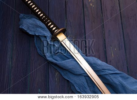 japan katana sword on the wood background with the blue shawl