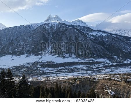 Winter in Greater Caucasus Mountains. Georgia (country). Mestia ski resort. Panoramic view from ski on snow mt. Ushba in sun winter day. Svaneti (Svanetia) region of Georgia.