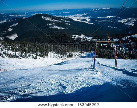 One skier climbs to the lifts on the snow-covered road in the mountains ski resort the view from the mountains beautiful landscape