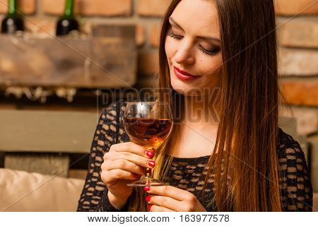 Elegant beauty lady long hair full make up wearing black dress tasting wine in rural cottage interior celler