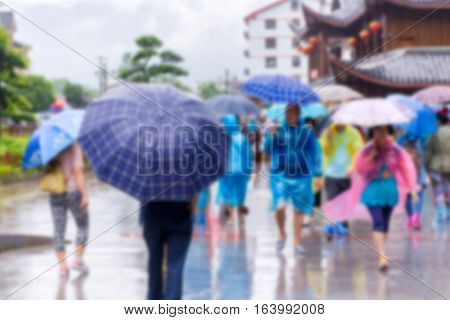 Blur Of People With Umbrella Walking In The Falling Rain