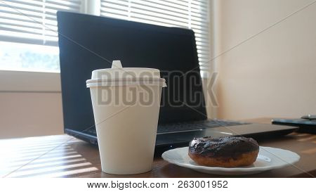 A Businessmans Desk With A Disposable Cup For Coffee And Fast Food. Open Laptop Computer. Breakfast 