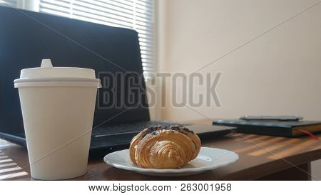 A Businessmans Desk With A Disposable Cup For Coffee And Fast Food. Open Laptop Computer. Breakfast 