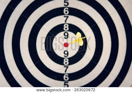 Dart Arrow Hitting The Target Of Dartboard On White Background. Hitting The Bulls Eye. Clear Aim. We