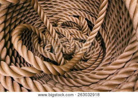 Thick Brown Rope Rolled Into A Roll. Background Texture