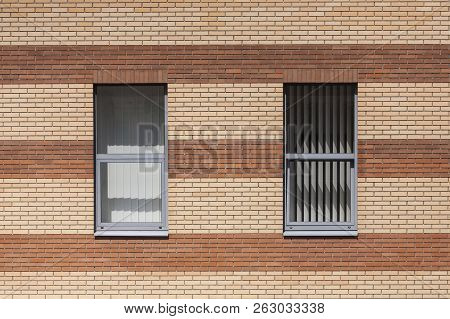 The Wall Of A Brick Building. The Windows Of The City House. Blinds And Shutters. Striped Red-yellow
