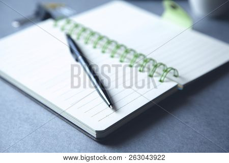 Pen On Notebook With Stationary On Desk