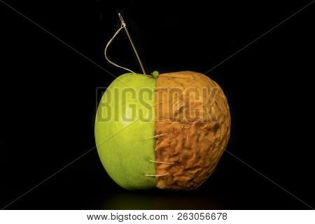 A Whole Apple Stitched With A Needle With White Threads And Composed Of Two Parts, Fresh Green And S