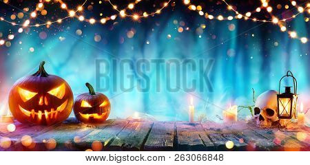 Halloween Party - Jack O Lanterns And String Lights On Table In Misty Forest