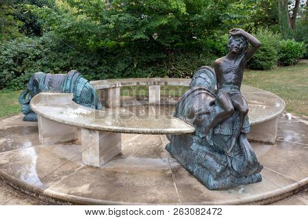 LEAMINGTON SPA, ENGLAND - August 10, 2018: An unusual bronze and marble seat sculpture with elephants and a boy in Jephson Gardens, Leamington Spa, England. By sculptor Nicholas Dimbleby in 1988.

