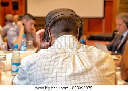 Unrecognizable People Using In Ear Headphones For Translation During Event Unrecognizable Business P