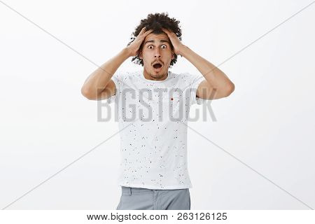 Head Spinning Round From Lots Of Info. Portrait Of Shocked And Astonished Handsome Hispanic Guy With