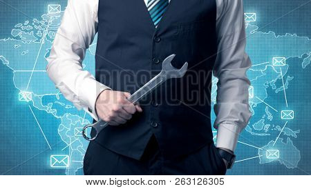 Businessman holding tool with global map graphic on the background