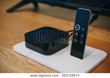 Berlin, August 29, 2018: Apple Tv Device And Remote Control Or Joystick. Modern Devices For Televisi