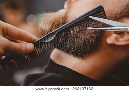 Close-up Of Barber Shearing Beard To Man In Barbershop