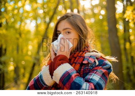 Woman With Napkin Sneezing In The Yellow Park. Sick People Has Runny Nose. Allergy Season. Woman Mak