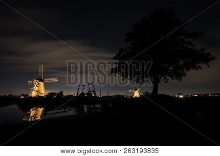These Beautiful Windmills In Kinderdijk Are Illuminated With White Light At The Blue Hour