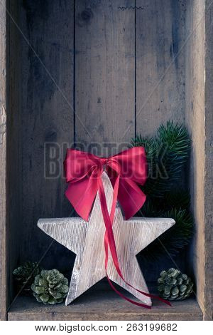Christmas decoration red ribbon on a star in a wooden box background