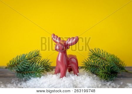 Christmas decoration red reindeer with twiggs in front of a yellow background