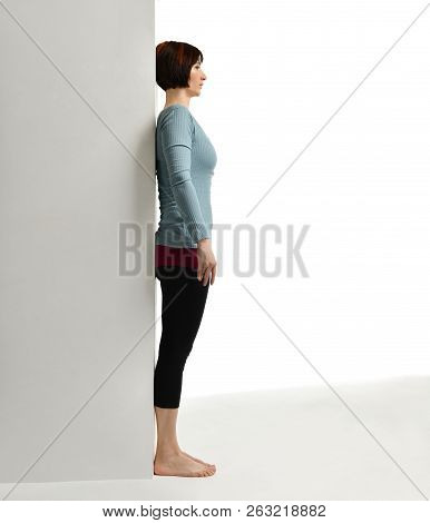 Woman Exercising Doing Postnatal Workout. Female Fitness Instructor Stretching Her Spine Near Wall I